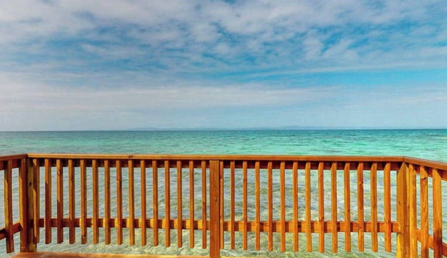 Overwater cabin with oceanfront deck, island kitchen & sea breeze views
